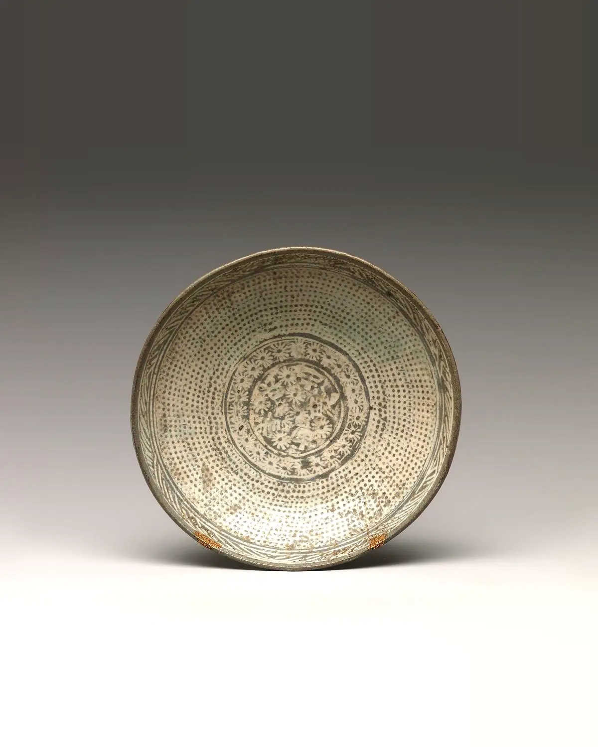 A buncheong dish stamped all over with tiny white chrysanthemums